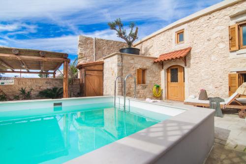 a swimming pool in front of a stone house at Villa Salis in Gonia