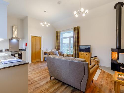 - un salon avec un canapé et une cuisinière dans l'établissement Merry Burn Barn - Uk3325, à Falstone