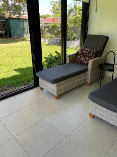 a screened in porch with a couch and a chair at Garden Hideaway-Entirely Private in Beecroft