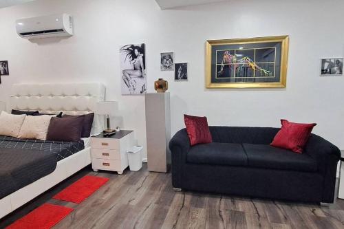 a living room with a couch and a bed at Kandi Paramount Executive 1BR 140sqm and 400mbps in Angeles