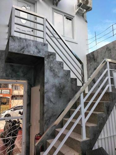 a stairway leading to a white building with a door at Kandi Paramount Executive 1BR 140sqm and 400mbps in Angeles