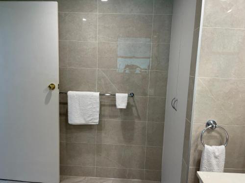 a bathroom with a shower with white towels at Garden Hideaway-Entirely Private in Beecroft