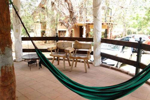 a hammock on a patio with a table and chairs at Cabaña WiFi Chimenea 15 Min de Pátzcuaro in Chapultepec