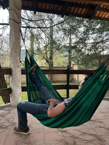 two people are laying in a hammock at Cabaña WiFi Chimenea 15 Min de Pátzcuaro in Chapultepec