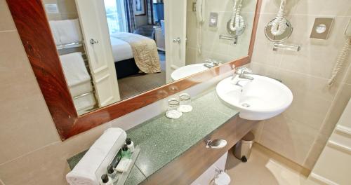a bathroom with a sink and a mirror at Harbour Heights Hotel in Poole