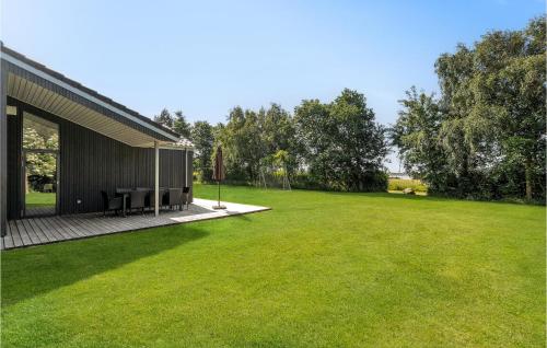 a house with a large lawn next to a building at 4 Bedroom Cozy Home In Spøttrup in Spottrup