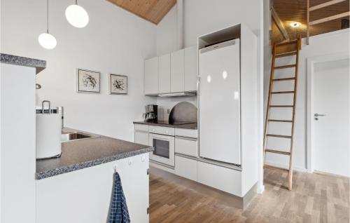 a kitchen with white cabinets and a ladder at Awesome Home In Tarm With Sauna in Tarm