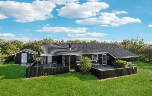 a small black house with a green yard at Awesome Home In Tarm With Sauna in Tarm