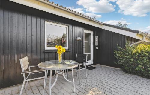 a patio with a table and chairs and a building at Awesome Home In Tarm With Sauna in Tarm