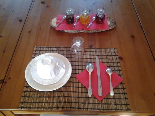 une table en bois avec une assiette, une fourchette et une cuillère dans l'établissement Domaine de Collen, à Lépine