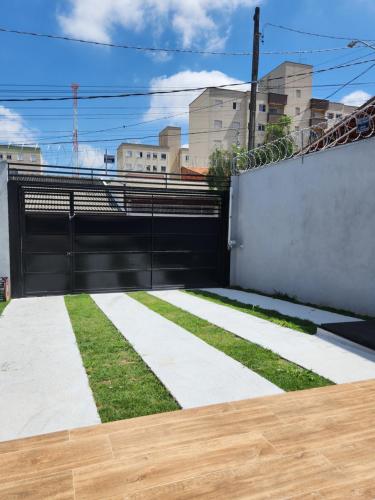 a black gate with grass in front of a building at Sobrado novo e lindo com piscina in São José dos Campos