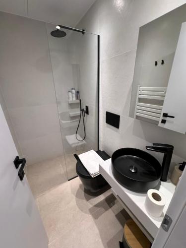 een badkamer met een zwart toilet en een glazen douche bij Resort Beach Living in Lagonisi in Kalívia Thorikoú