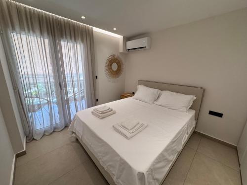 een slaapkamer met een bed met twee handdoeken erop bij Resort Beach Living in Lagonisi in Kalívia Thorikoú