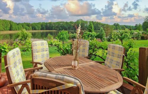 a wooden table and chairs with a view of a lake at Wohnung Templin Ot Dargersdorf in Dargersdorf