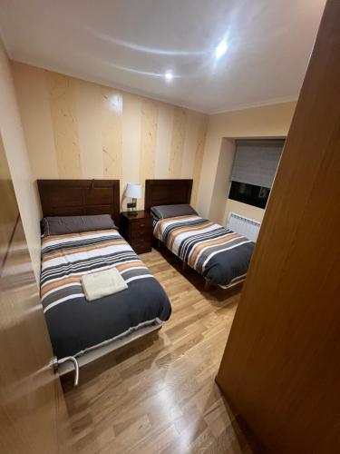 sypialnia z dwoma łóżkami i oknem w obiekcie Villa Adilia w mieście Padornelo