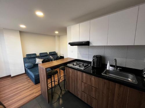 a kitchen with a sink and a couch in a room at Apartamento de una habitación in Pasto