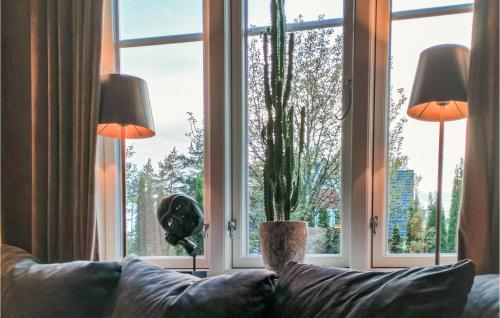 a living room with a couch and a large window at 2 Bedroom Cozy Home In Halden in Halden