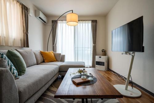 a living room with a couch and a flat screen tv at Labradorite in Sapporo