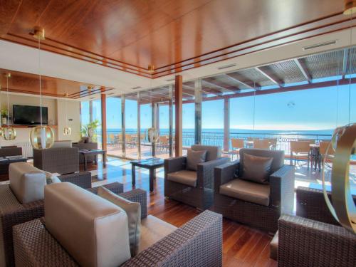 a lobby with chairs and tables and a view of the ocean at Hotel Servigroup Montíboli in Villajoyosa