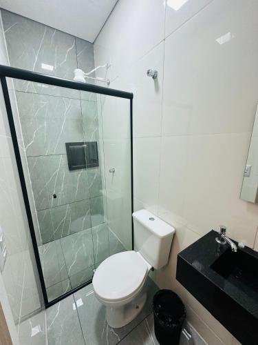 a bathroom with a toilet and a glass shower at On Hotel Campos do Jordao centro capivari e Passeio Quadriciclo in Campos do Jordão