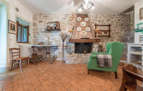 a living room with a fireplace and a green chair at Beautiful Apartment In Loc, Scalabrelli in Catabbio