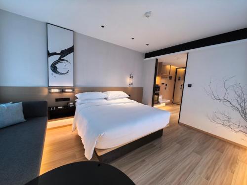 a bedroom with a white bed and a large window at Fairfield by Marriott Hangzhou Qiantang in Hangzhou