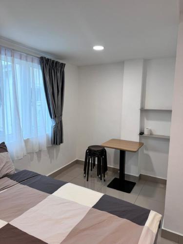 a bedroom with a bed and a table and a window at Famosa 2 Stay at Ong Kim Wee in Melaka