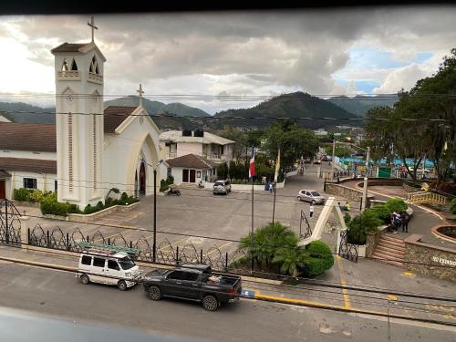 a church with cars parked in front of a street at Hotel El Parque Constanza in Constanza
