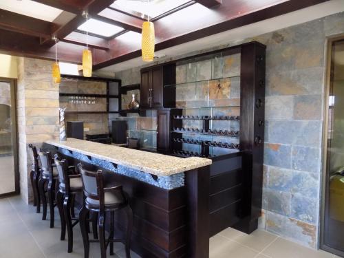 a bar in a restaurant with chairs and a counter at Hotel Plaza Real Suites & Apartments San Jose in San José