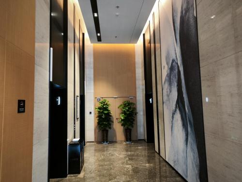 a hallway with two potted plants in a building at Fairfield by Marriott Hangzhou Qiantang in Hangzhou