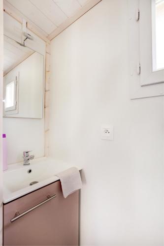 une salle de bain avec un lavabo et un miroir dans l'établissement Camping Les Vernieres La Bourboule Sancy, à La Bourboule