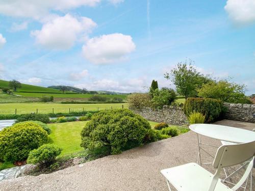 a patio with a table and chairs in a garden at Lupton Hall Cottages in Lupton