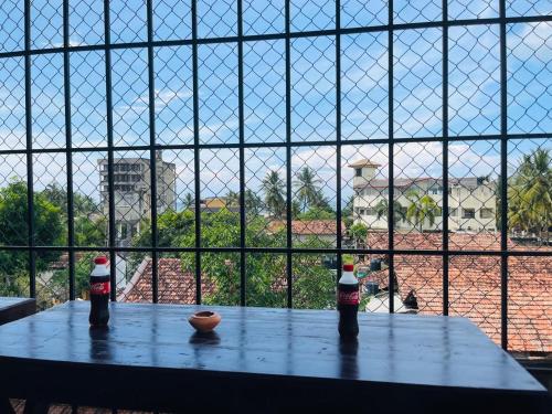 two soda bottles sitting on a table in front of a window at Emerald Coast Hotel Negombo in Daluwekotuwa