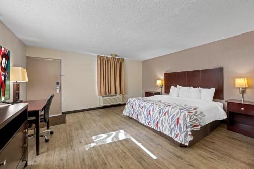 a hotel room with a bed and a desk at Red Roof Inn Abingdon in Abingdon
