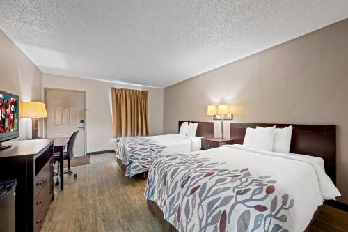a hotel room with two beds and a desk at Red Roof Inn Abingdon in Abingdon