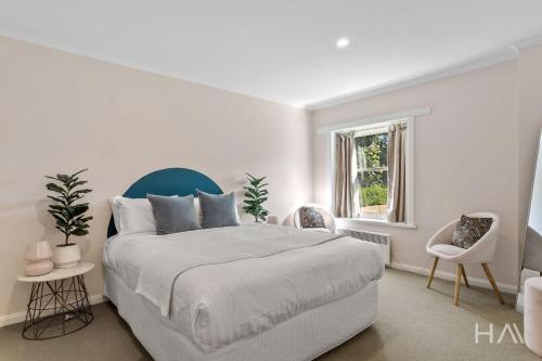 a white bedroom with a large bed and a window at Rose Gold Hideaway in Kings Park