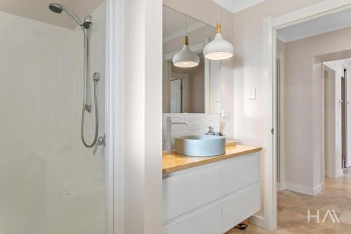 a white bathroom with a sink and a shower at Rose Gold Hideaway in Kings Park