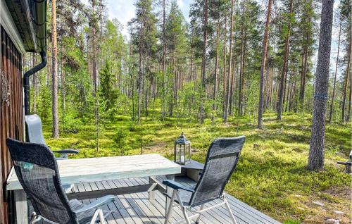 ein Holztisch und Stühle auf einer Veranda mit Wald in der Unterkunft Amazing Home In Østby in Østby