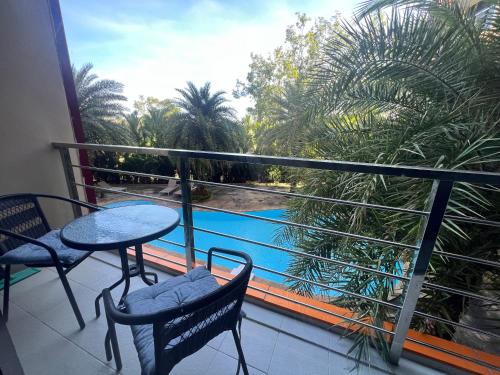 a balcony with a table and chairs and a view of a pool at Mai Khao Serenity in Ban Mai Salae