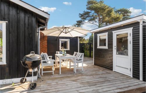 a backyard deck with a grill and a table and chairs at Stunning Home In Nykøbing Sj With Wifi in Nykøbing Sjælland