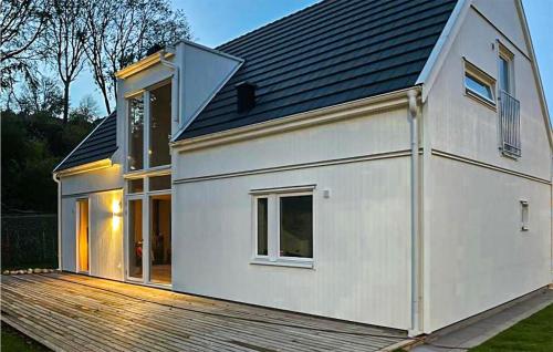 a white house on top of a wooden deck at Stunning Home In Båstad With Wifi in Båstad
