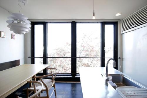 a kitchen with a large window and a table and chairs at Townhouse Asahikawa in Asahikawa