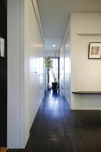 a hallway with white walls and wooden floors at Townhouse Asahikawa in Asahikawa