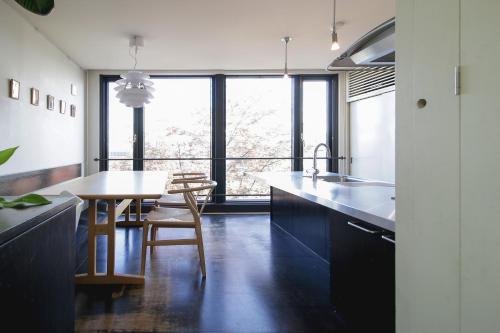 a kitchen with a table and a dining room at Townhouse Asahikawa in Asahikawa