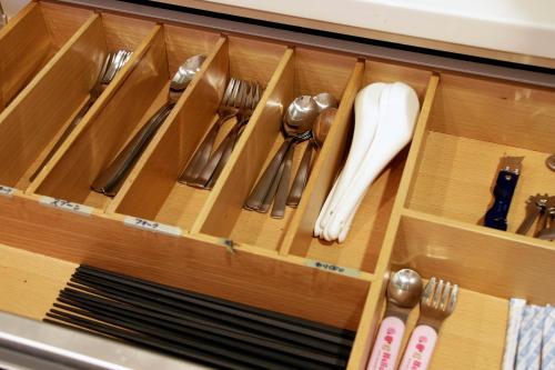 a drawer filled with utensils in a cabinet at Townhouse Asahikawa in Asahikawa