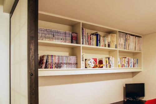 a room with shelves filled with books at Townhouse Asahikawa in Asahikawa