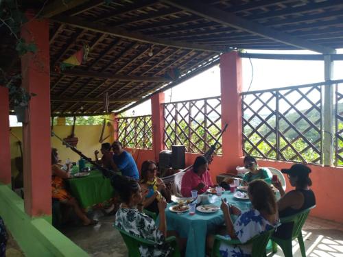 a group of people sitting at a table in a restaurant at Pousada Recanto Verde in Sao Benedito do Sul