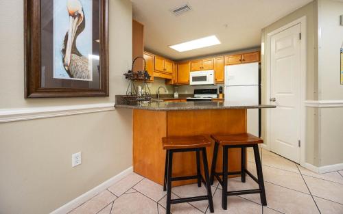 a kitchen with two bar stools and a counter top at Phoenix X 211 condo in Orange Beach