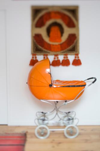 an orange wheelbarrow against a wall with a picture at Une Chambre Chez Dupont in Bordeaux