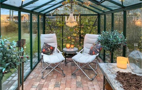 a green greenhouse with two chairs and a table at Nice Home In Hjältevad With Sauna in Hjältevad